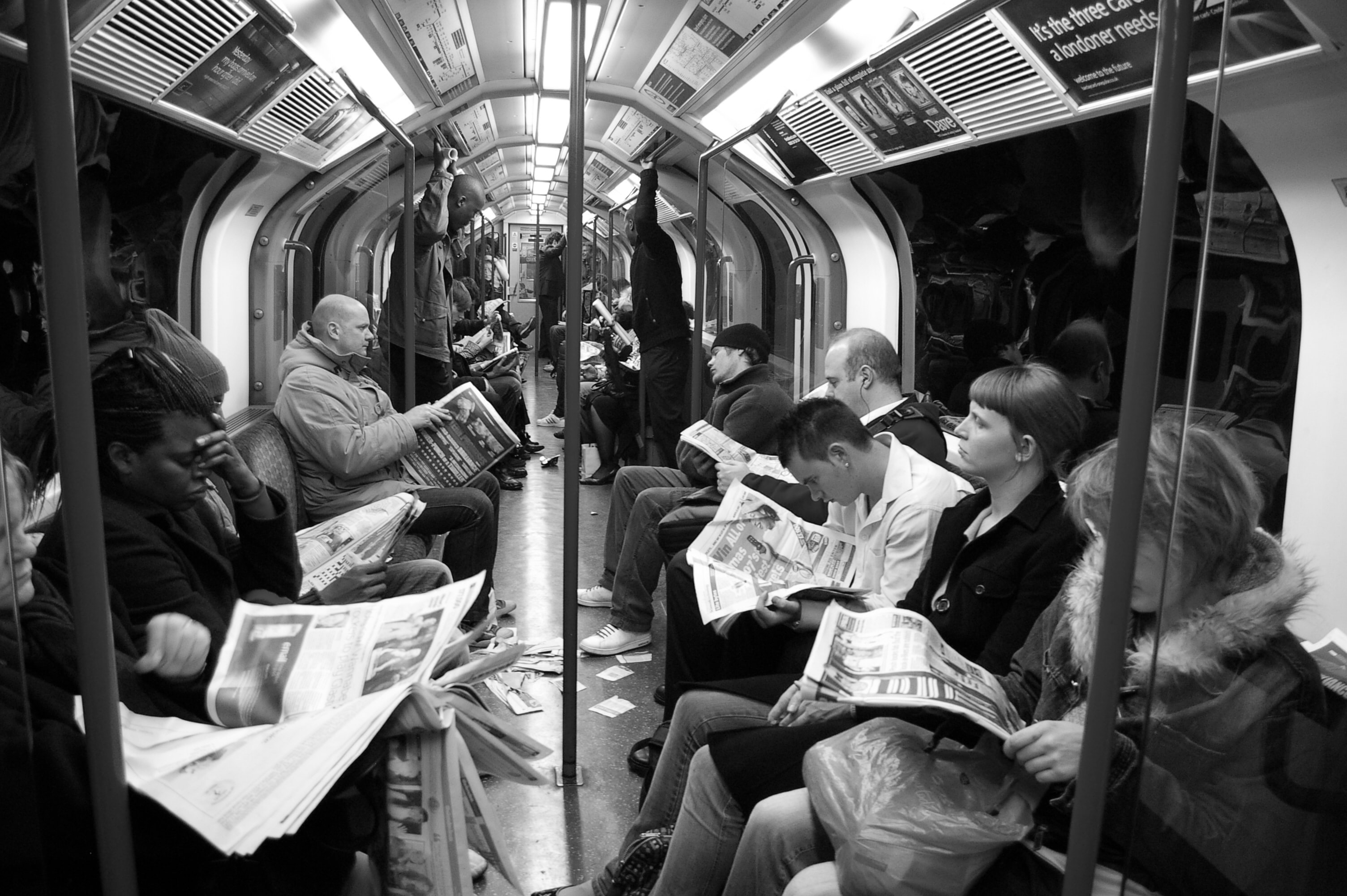 People reading newspapers on the London Tube
